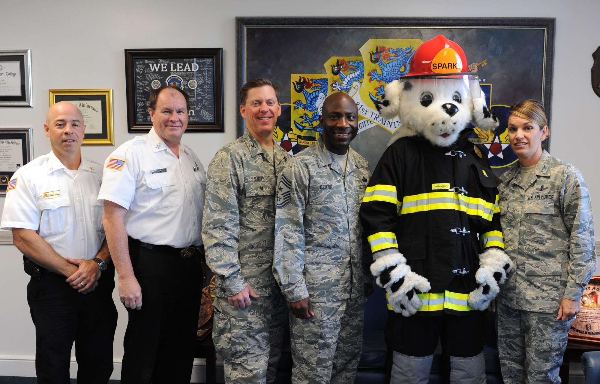 Sparky the Fire Dog poses for a photo with 81st Training Wing leadership and Keesler Fire Department members at the 81st TRW headquarters building to kick off Fire Prevention Week Oct. 11, 2016, on Keesler Air Force Base, Miss. The weeklong event includes fire drills, literature hand-outs and stove fire demonstrations around the base and concludes with an open house at the fire department Oct. 15. (U.S. Air Force photo by Kemberly Groue/Released)