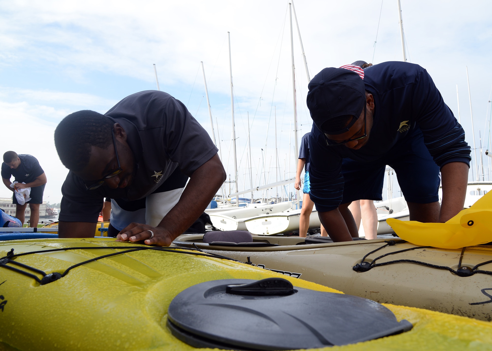 Senior Airman Koraye Williams, 56th Comptroller Squadron finance technician, and Senior Airman Vernon Sparks, 56th Force Support Squadron career development technician, clean the kayaks during the National Veterans Summer Sports Clinic Sept. 21, 2016 at San Diego, Ca. (U.S. Air Force photo by Senior Airman Devante Williams)
