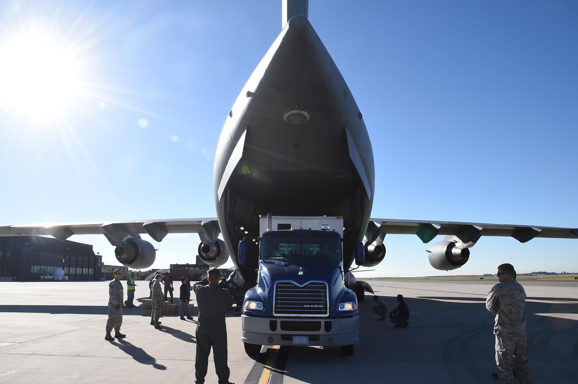 A loadmaster directs the Advanced Ground Mobile driver onto the ramp of a C-17 Globemaster III. During the loading process, skilled drivers must maneuver the AGM within an accuracy area of just a few inches, taking care not to damage the plane or semitrailer. (U.S. Air Force photo/2nd Lt. Darren Domingo)