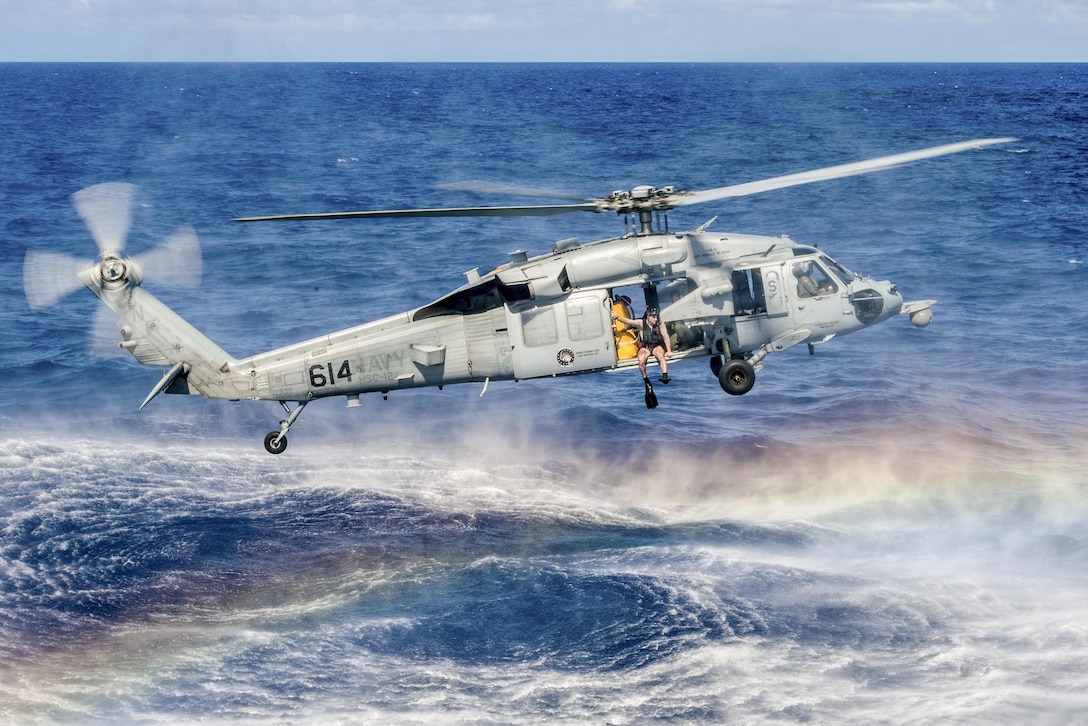 Navy Petty Officer 3rd Class Curtis Kuchera prepares to jump from an MH-60S Seahawk during search and rescue training in the Philippine Sea, Oct. 7, 2016. This training enables sailors to experience real-world proficiency in open-ocean rescue procedure and equipment. The sailors are assigned to the USS Ronald Reagan, which is supporting security and stability in the Indo-Asia-Pacific region. Navy photo by Petty Officer 3rd Class Nathan Burke