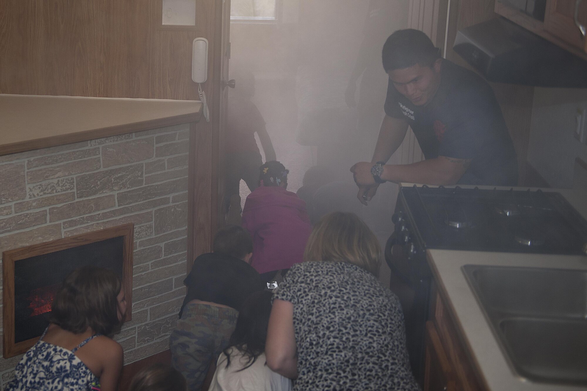 Children at Kadena Elementary School practice getting low and finding an exit in case of a fire during fire prevention week Oct. 5, 2016, at Kadena Air Base, Japan. This year’s fire prevention week slogan is ‘don’t wait - check the date! Replace smoke alarms every 10 years’. (U.S. Air Force photo by Airman 1st Class Corey M. Pettis)