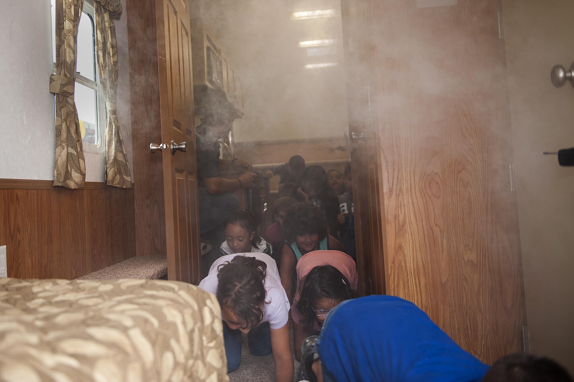 Children at Kadena Elementary School practice getting low and finding an exit in case of a fire during fire prevention week Oct. 5, 2016, at Kadena Air Base, Japan. Fire prevention week is designed to teach kids about fire safety, smoke alarms and fire escape routes. (U.S. Air Force photo by Airman 1st Class Corey M. Pettis)