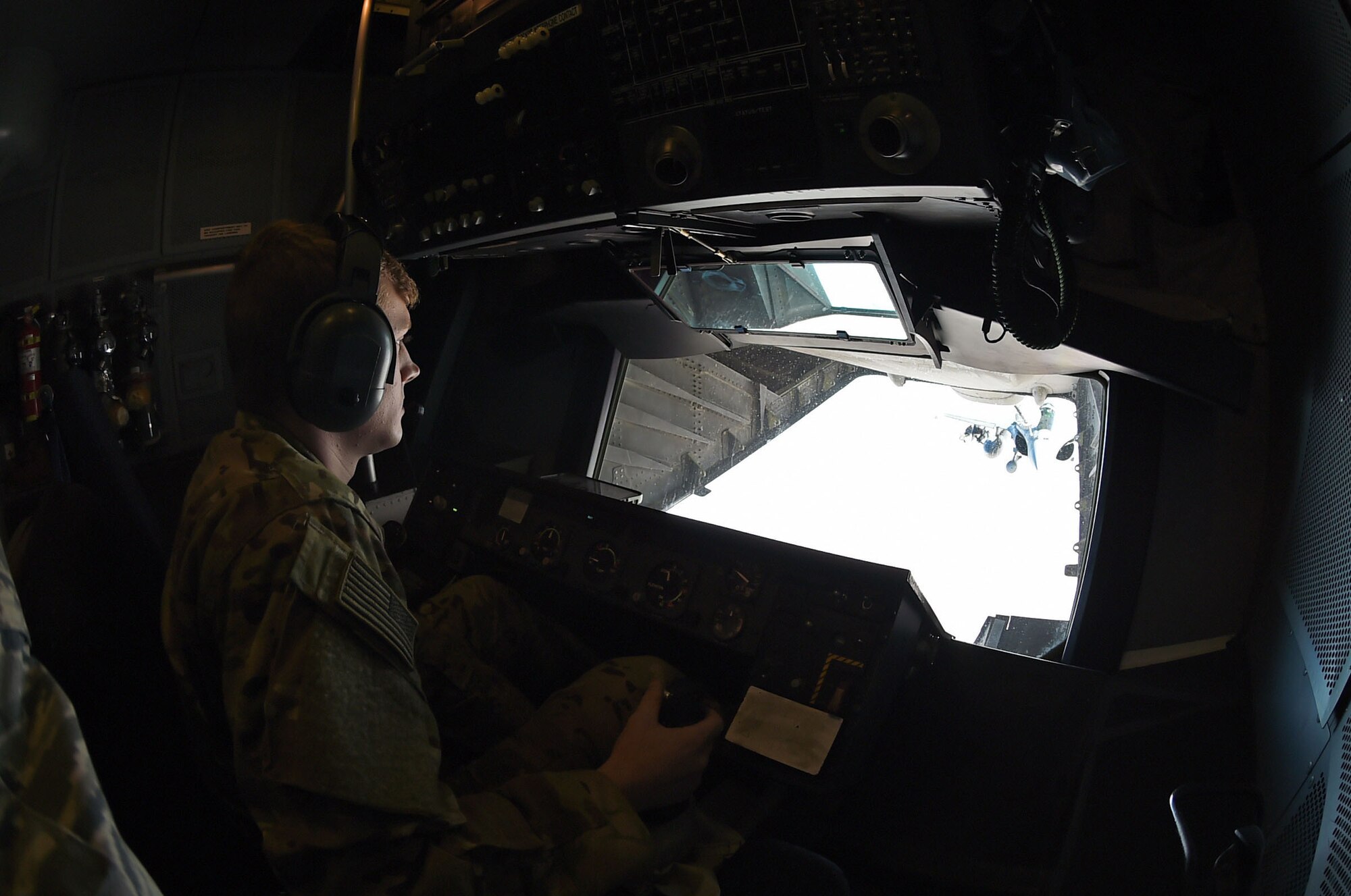 Airman 1st Class Aaron, 908th Expeditionary Air Refueling Squadron in-flight refueler, operates the centerline drogue in the rear of a KC-10 Extender over an undisclosed location in Southwest Asia, Oct. 9, 2016. Aaron is responsible for operating and monitoring aircraft refueling.(U.S. Air Force photo by Tech. Sgt. Christopher Carwile)