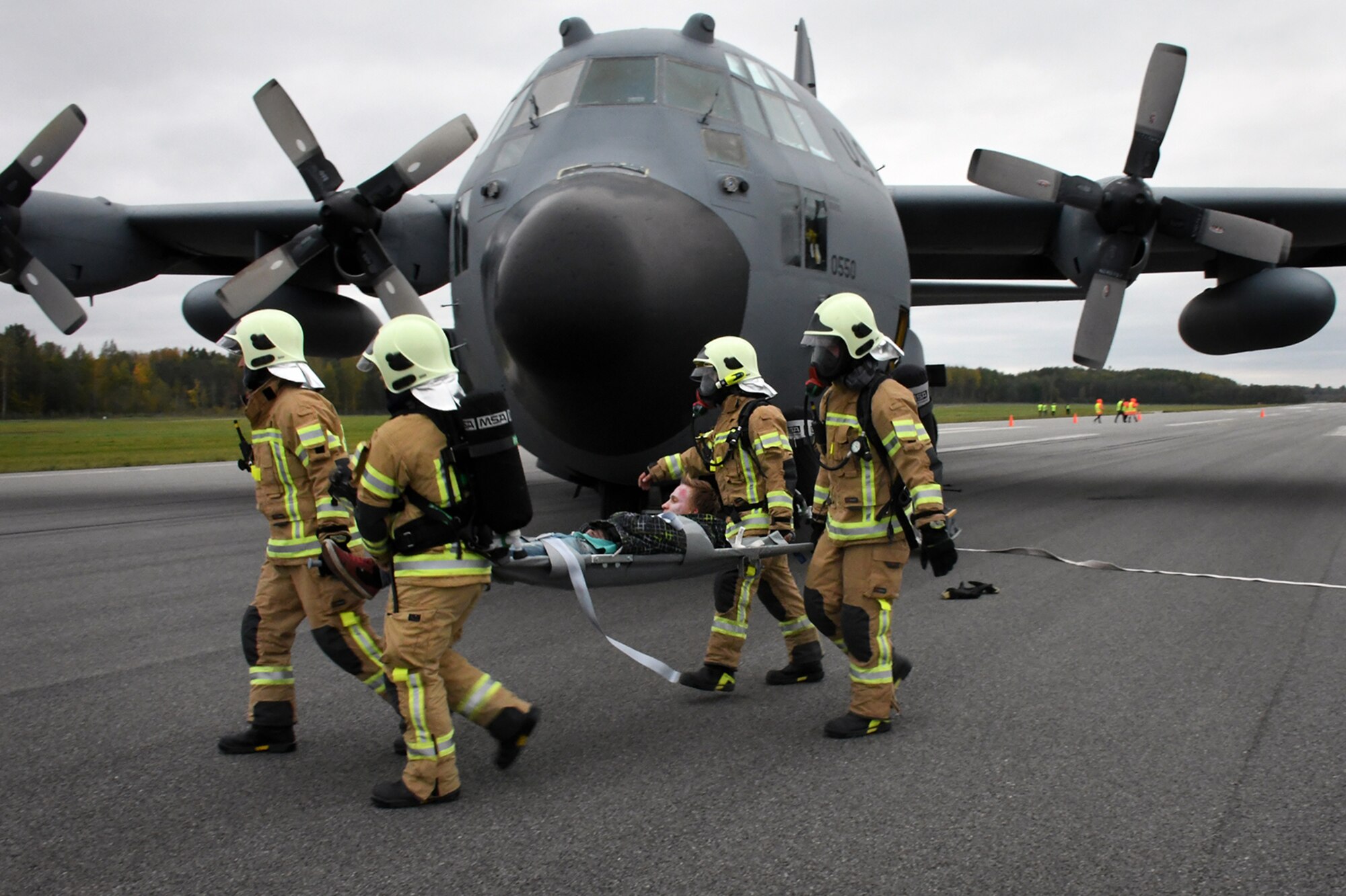 Latvian fire and rescue emergency responders evacuate an exercise participant from a C-130H from Dobbins Air Reserve Base, Ga., positioned on the runway in a simulated crash at Lielvarde Air Base, Latvia, during Sky Fist, Oct. 6, 2016. Sky Fist was a bilateral aircraft mishap training exercise designed to strengthen the partnership between the U.S. and Latvia. (U.S. Air Force photo by Staff Sgt. Alan Abernethy)