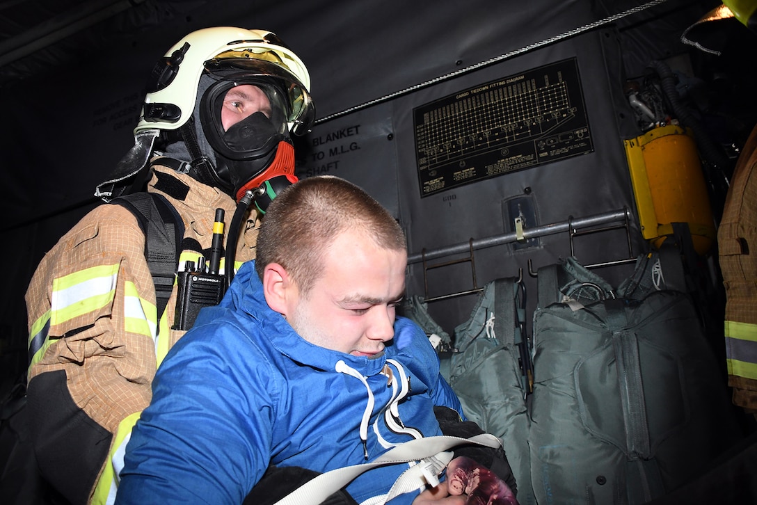 A Latvian fire and rescue emergency responder evacuates an exercise participant from a 94th Airlift Wing C-130H positioned on the runway in a simulated crash at Lielvarde Air Base, Latvia, during Sky Fist, Oct. 6, 2016. Sky Fist was a bilateral, aircraft mishap training exercise designed to strengthen the partnership between the U.S. and Latvia. (U.S. Air Force photo by Staff Sgt. Alan Abernethy)