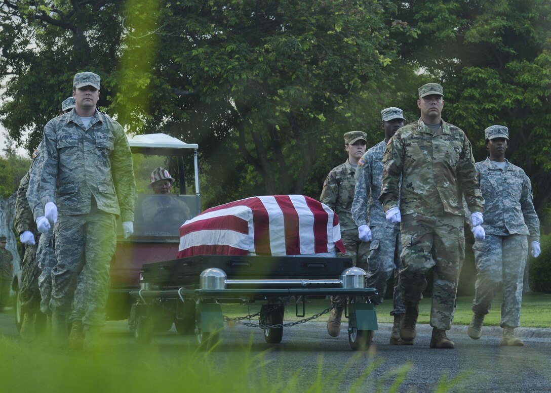 A Defense POW/MIA Accounting Agency (DPAA) honor guard detail escorts a set of unknown remains during a disinterment ceremony at the National Memorial Cemetery of the Pacific, Honolulu, Hawaii, June 13, 2016. DPAA members gathered to exhume the remains of eight unidentified remains from the Korean War era. After the ceremony, the remains were transported with honors to the DPAA facility where they will undergo DNA testing and possible identification. DPAA’s mission is to provide the fullest possible accounting for our missing personnel to their families and the nation. 