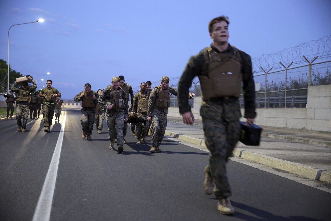 Marines with Special Purpose Marine Air-Ground Task Force Crisis Response-Africa carry a litter, ammo cans, and water jugs while conducting a casualty evacuation drill during Corporals Course at Naval Air Station Sigonella, Italy, September 22, 2016.  Thirty-five Marines with SPMAGTF-CR-AF completed the three-week course which included classes on land navigation, sword and guidon manual, fire team and squad formations, and included opportunities to develop the NCO’s mentoring and leadership skills.  (U.S. Marine Corps photo by Cpl. Alexander Mitchell/released)