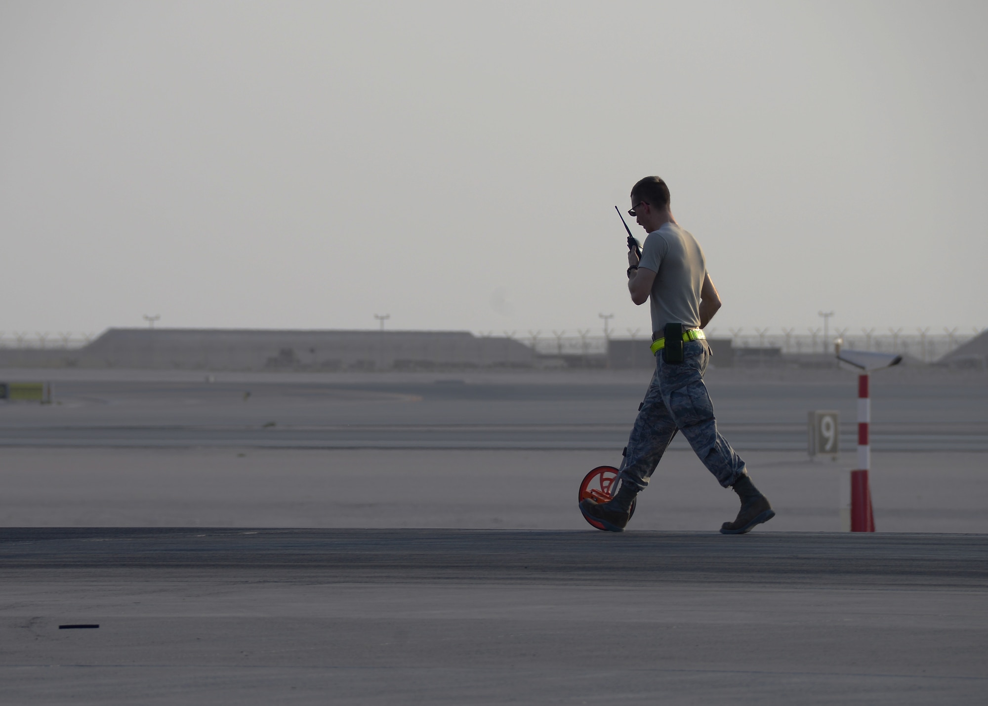 Tech. Sgt. Kenneth Mayfield, 379th Expeditionary Civil Engineer Squadron barrier maintenance NCO in-charge, measures how far the cable for the Aircraft Arresting System went out during a certification test Oct. 9, 2016, at Al Udeid Air Base, Qatar. The barrier maintenance section re-certifies the AAS annually to ensure it is operational and ready to use at a moment’s notice. (U.S. Air Force photo/Senior Airman Miles Wilson/Released)