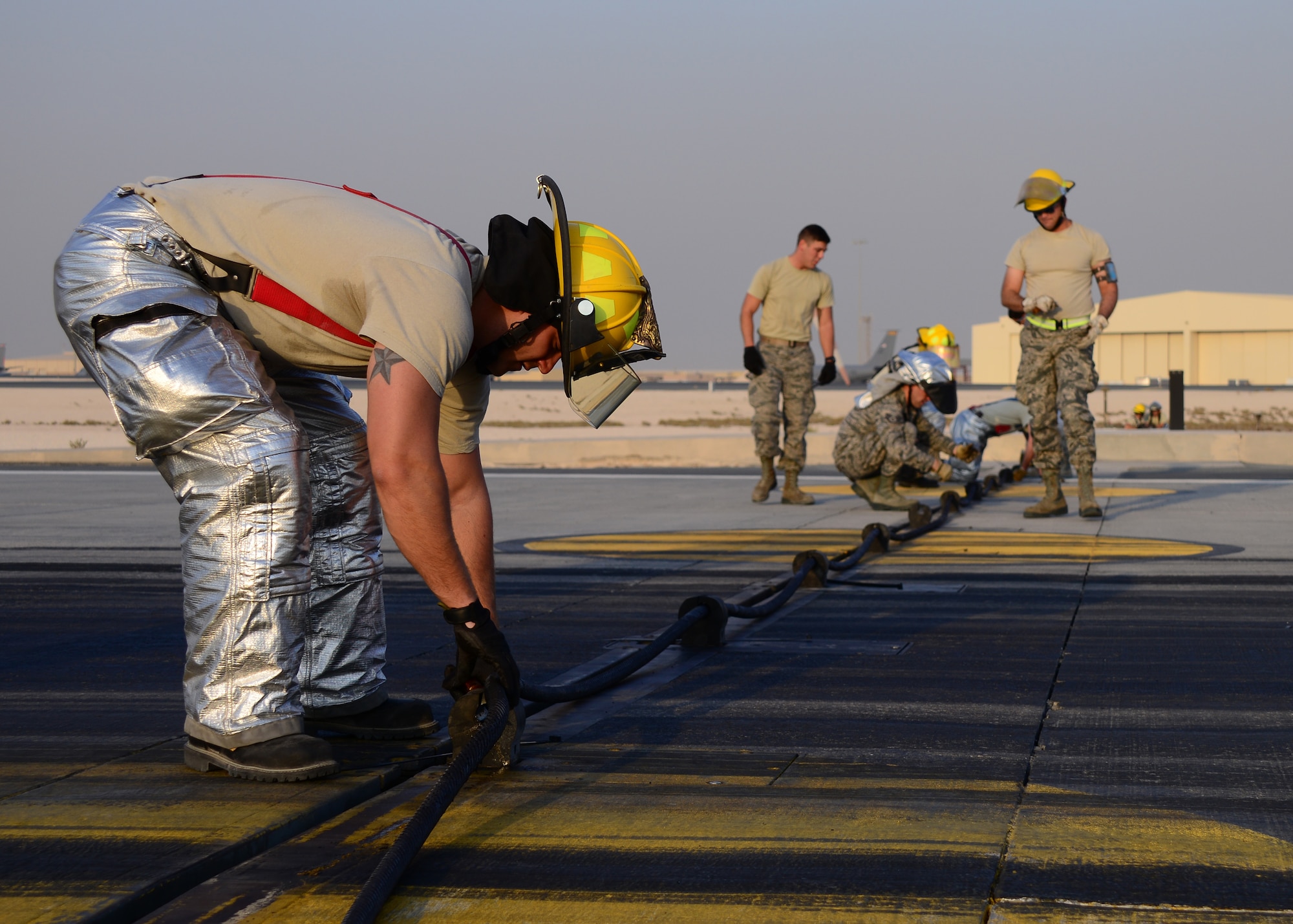 Staff Sgt. Tyson Hageny, 379th Expeditionary Civil Engineer Squadron firefighter, attaches the Aircraft Arresting System cable to the Barrier Arresting Kit, known as the BAK-14, Oct. 9, 2016, at Al Udeid Air Base, Qatar. The BAK-14 raises and lowers the cable on the runway, and it works in conjunction with the BAK-12 system, which reels in and keeps tension on the cable. The systems work together to provide additional assistance during an emergency stop for aircraft taking off and landing on the runway. (U.S. Air Force photo/Senior Airman Miles Wilson/Released)