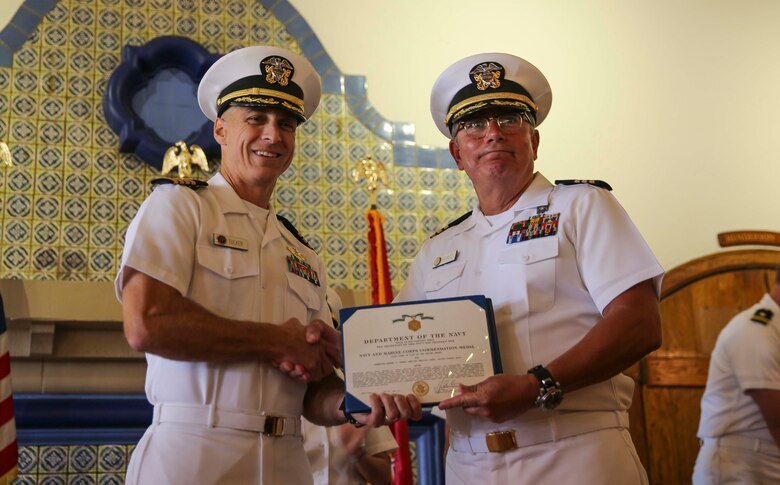 Captain Mark Tucker (L), Naval Medical Center San Diego, poses with Cmdr. Rafael C. Perez’s (ret.), division officer, Sports and Medicine Rehabilitation Center, after presenting him with a Navy and Marine Corps commendation medal during his retirement ceremony at the Bay View Restaurant at MCRD San Diego, Oct. 7. Perez served for 44 years and three months in the U.S. Navy, and he was deployed several times.