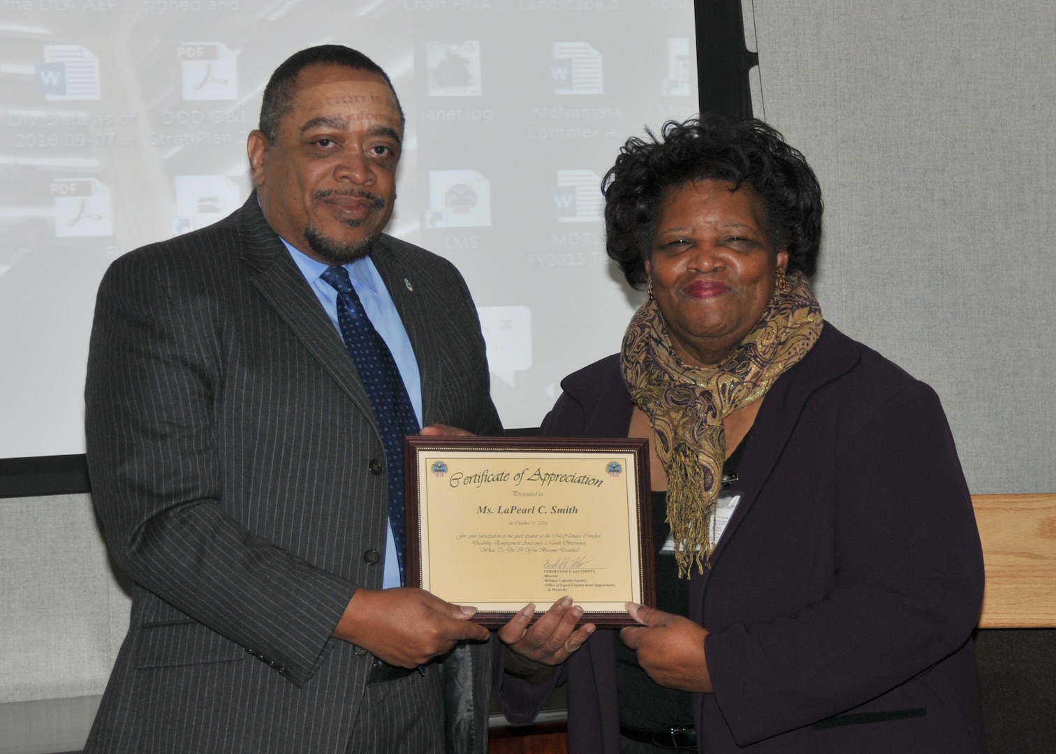 DLA EEO Director Ferdinand LeCompte presents a certificate of appreciation to LaPearl Smith, business development manager at the Virginia Department for Aging and Rehabilitative Services, Oct. 11, 2016. 