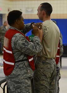 A member of the 633rd Medical Group administers flu vaccinations during the flu point-of-distribution exercise at the Langley Community Commons, Joint Base Langley-Eustis, Va., Oct. 5, 2016. The flu POD allowed for shorter wait times for U.S. service members for two days, and one day for retirees, dependents and anyone else who has medical coverage through TRICARE. (U.S. Air Force photo by Staff Sgt. Teresa J. Cleveland)