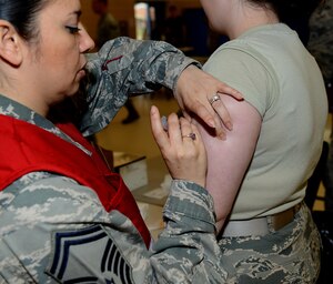 A member of the 633rd Medical Group administers a flu vaccination during the flu point-of-distribution exercise at the Langley Community Commons, Joint Base Langley-Eustis, Va., Oct. 5, 2016. Members who were unable to get their vaccine at the POD can visit the walk-in Immunization clinic to ensure they are up-to-date and prepared for this year’s flu season. (U.S. Air Force photo by Staff Sgt. Teresa J. Cleveland)