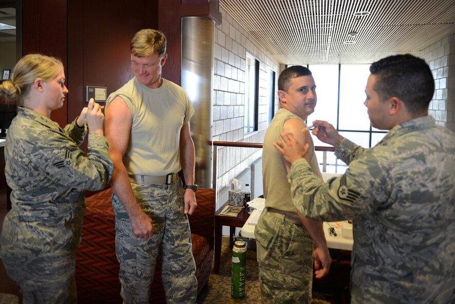 Senior Airman Sara Valeski (left), 47th Medical Operations Squadron Flight Medicine medical technitian, and Staff Sgt. Shon Nguyen (right), 47th MDOS Family Health flight chief, administer influenza vaccinations to Col. Thomas Shank (second from the left), 47th Flying Training Wing commander, and Chief Master Sgt. George Richey, 47th FTW command chief on Laughlin Air Force Base, Texas, Oct. 4, 2016. The Laughlin Immunization Clinic will be available to provide free flu vaccines from 7:30 until 11:45 a.m. and 1 until 4 p.m. Monday through Friday. (U.S. Air Force photo/Senior Airman Ariel D. Partlow)