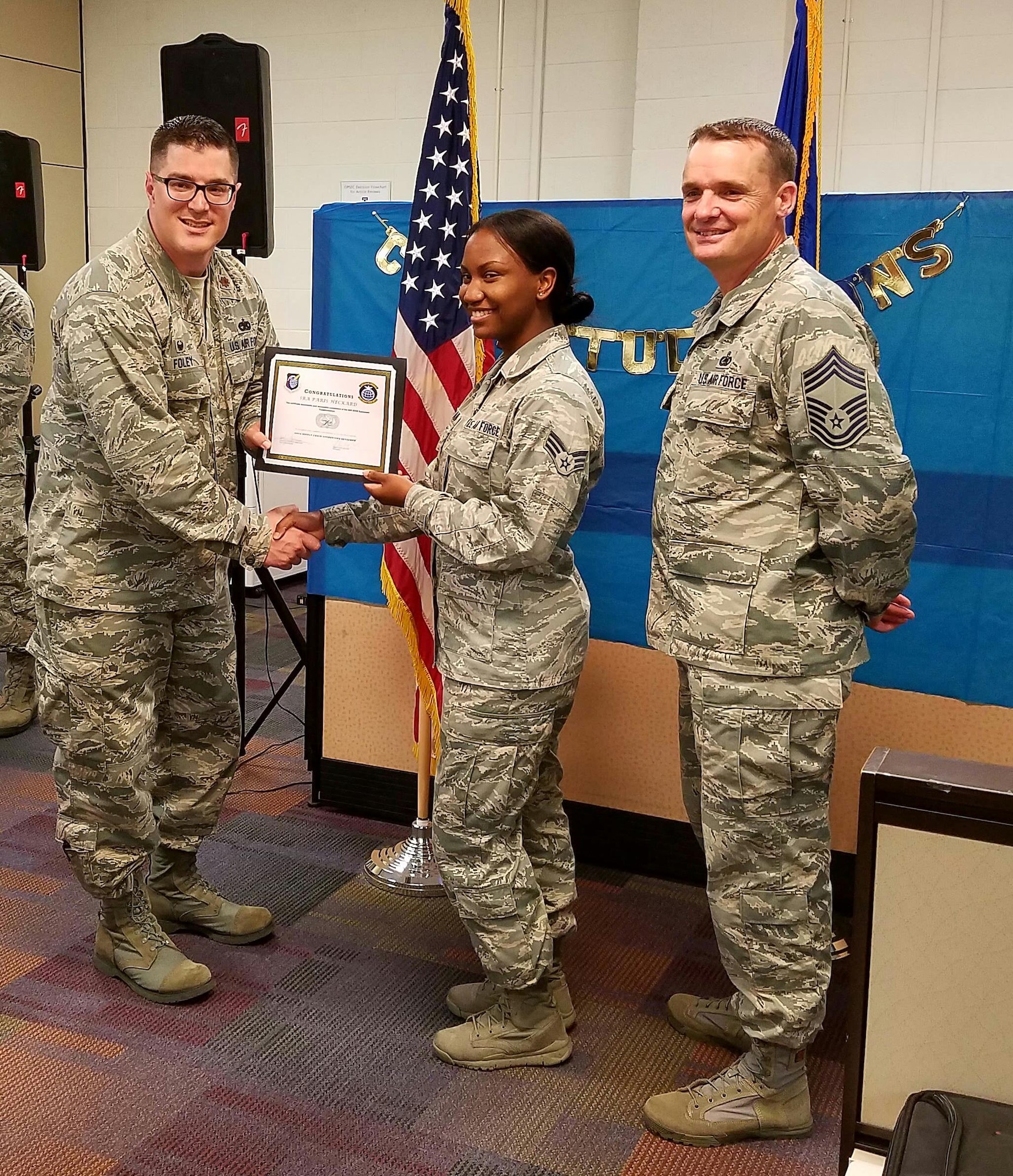 U. S. Air Force Maj. John Foley, 440th Supply Chain Operations Squadron commander, congratulates Senior Airman Paris Heckard, 440th SCOS equipment management technician, during the 440th SCOS Equipment Transformation graduation at Joint Base Langley-Eustis, Va., Oct. 6, 2016. The 440th SCOS oversees all non-airborne equipment accounts including communications, radar, weather and munitions for the Air Force. (U.S. Air Force photo by Beverly Joyner)
