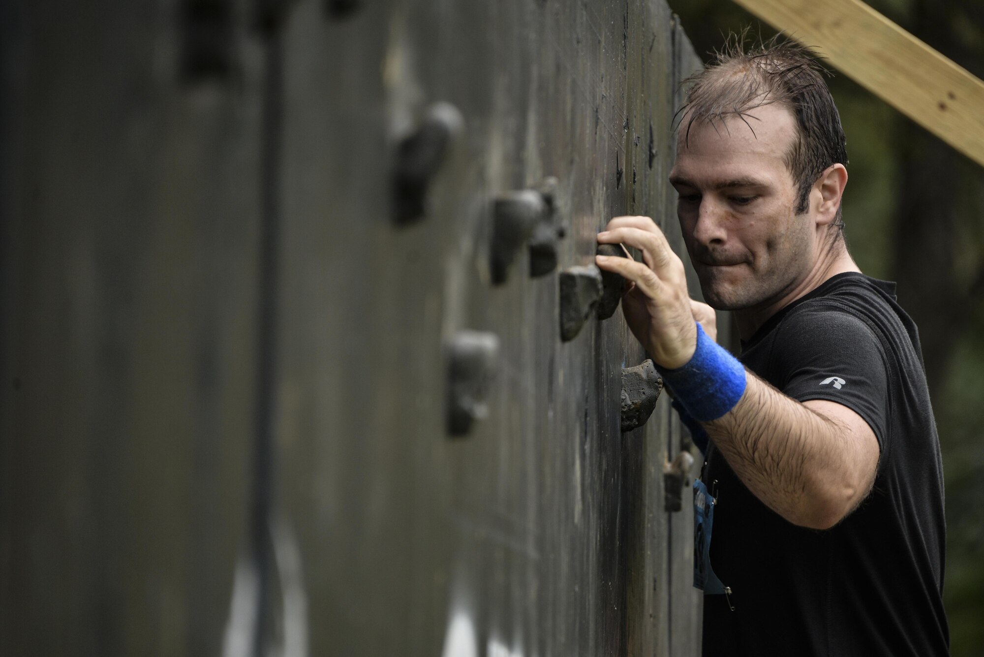 Staff Sgt. Bradley, 29th Intelligence Squadron, maneuvers through a rock climbing wall with only a one-inch gap along a 25-foot wall during the 2016 Savage Race October 8, 2016 at Kennedyville, Md. 70th ISRW participants endured a seven-mile obstacle course of cargo net walls, creeks, ice cold water and climbing to test their stamina and strength as a team. (U.S. Air Force photo/Staff Sgt. Alexandre Montes)
