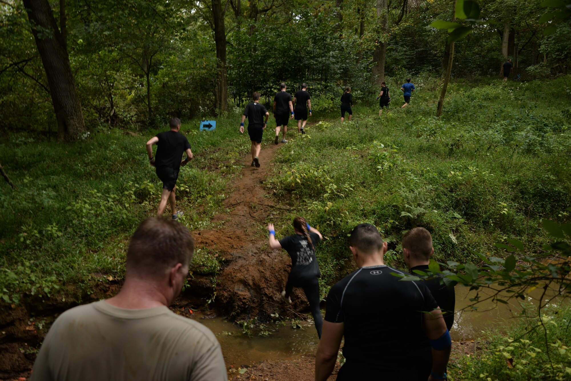 Airmen from the 70th Intelligence, Surveillance and Reconnaissance Wing cross a creek as they progress toward the end of the 2016 Savage Race October 8, 2016 at Kennedyville, Md. 70th ISRW participants endured a seven-mile obstacle course of cargo net walls, creeks, ice cold water and climbing to test their stamina and strength as a team. (U.S. Air Force photo/Staff Sgt. Alexandre Montes)