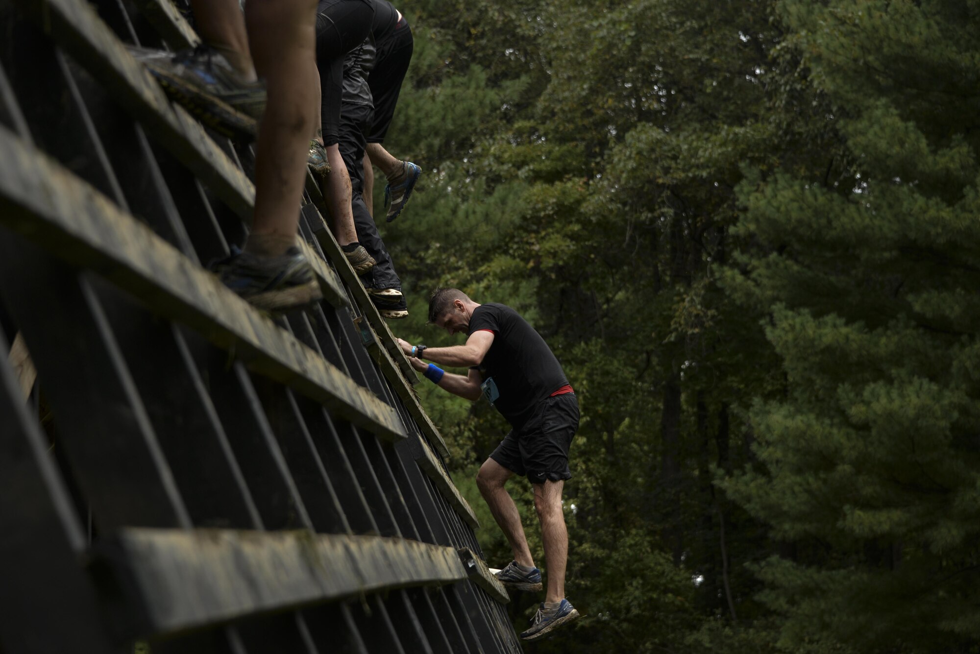 Col. Gregory Gillinger, 70th Intelligence, Surveillance and Reconnaissance Wing vice commander, climbs up a wooden ladder during the 2016 Savage Race October 8, 2016 at Kennedyville, Md. 70th ISRW participants endured a seven-mile obstacle course of cargo net walls, creeks, ice cold water and climbing to test their stamina and strength as a team. (U.S. Air Force photo/Staff Sgt. Alexandre Montes)