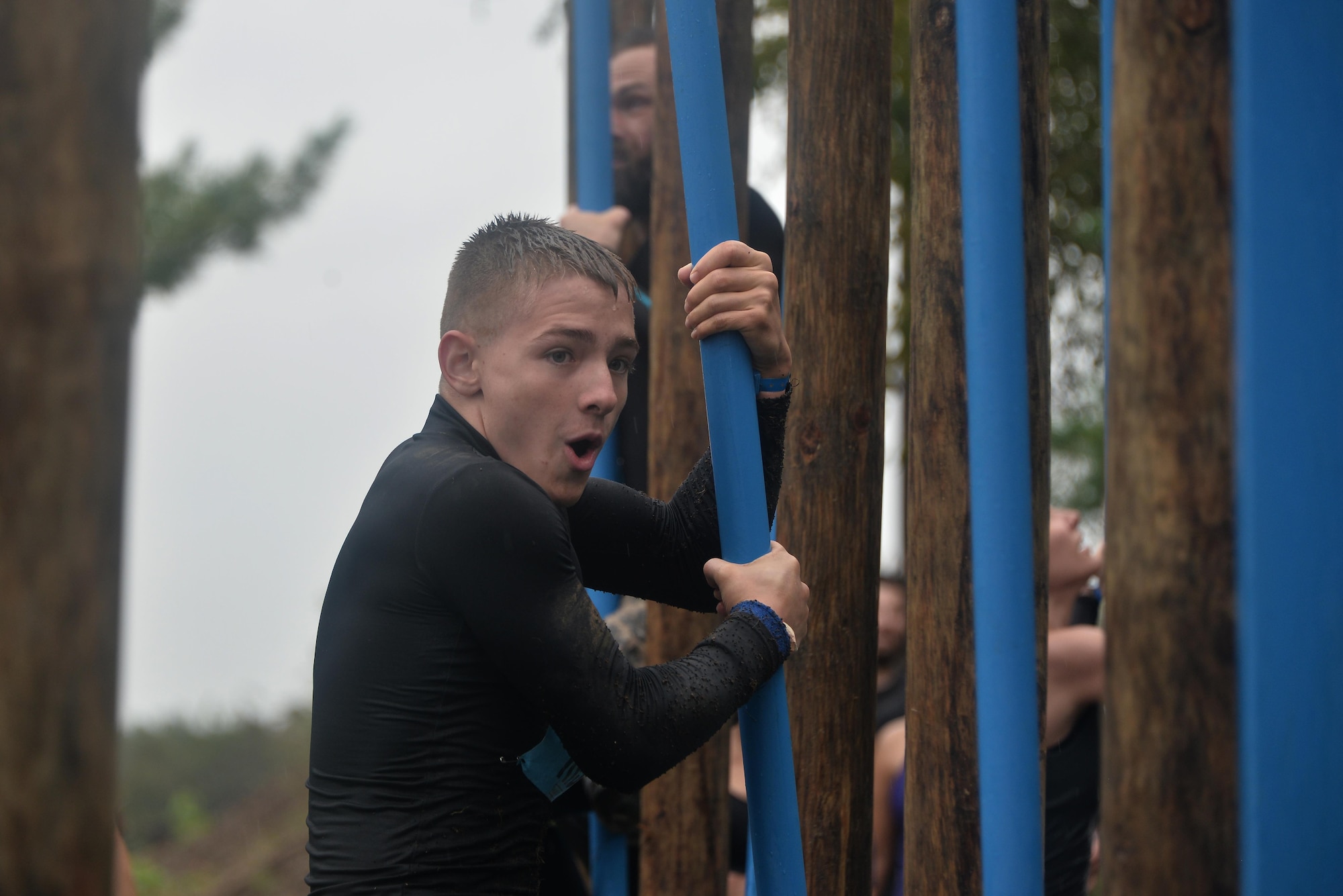 Jackson Hensley calculates how to complete the final obstacle of moving around poles without touching the ground to complete the 2016 Savage Race October 8, 2016 at Kennedyville, Md. 70th ISRW participants endured a seven-mile obstacle course of cargo net walls, creeks, ice cold water and climbing to test their stamina and strength as a team. (U.S. Air Force photo/Staff Sgt. Alexandre Montes)