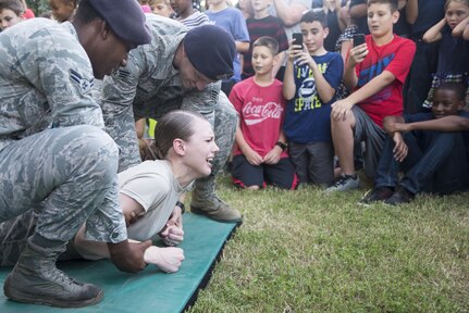 Airman 1st Class Hannah Herman, 902nd Security Forces Squadron Visitor Control Center clerk, participates in a taser demonstration during National Night Out at Joint Base San Antonio-Randolph Oct. 4, 2016. NNO is a crime, drug and violence prevention event sponsored by the National Association of Town Watch.