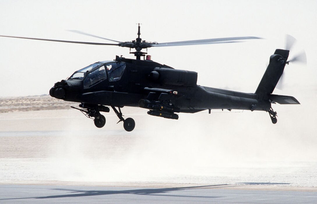 AH-64 Apache helicopter taking off from air base.