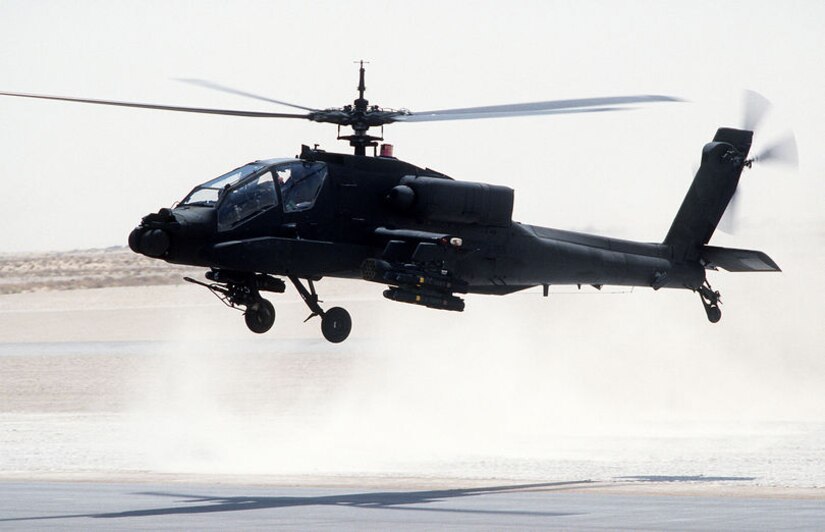 AH-64 Apache helicopter taking off from air base.