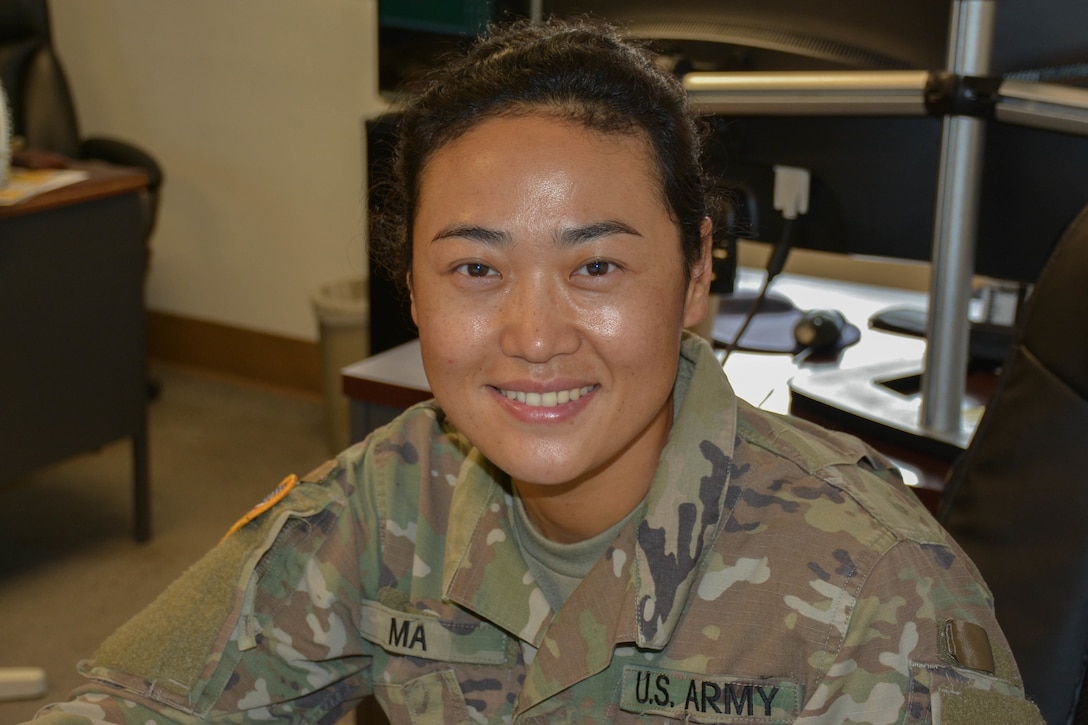 Army Pfc. Li Ma, a finance specialist with the 24th Finance Management Support Unit, smiles for a photo in her office at Fort Stewart, Ga., Oct. 3, 2016. Army photo by Sgt. Caitlyn C. Smoyer