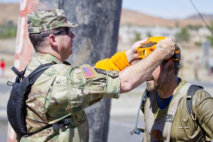 LAKE ELSINORE- Calif. (October 8, 2016) -
Chief Warrant Officer 3 Jason Arndt, 304th Sustainment Brigade, presents Tough Mudder finishers with their headbands. The Army Reserve is a sponsor for the Southern California Tough Mudder where participants run a basic-training like course over ten miles long with 22 different team obstacles.

(US Army photo by Cpl. Timothy Yao)
