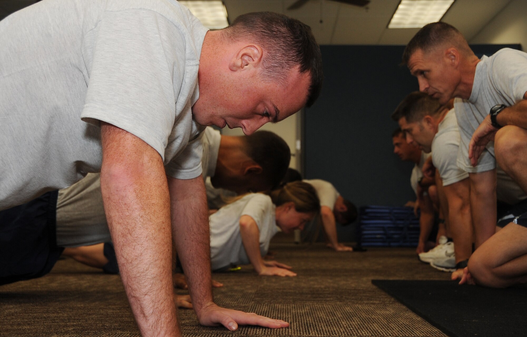 Airmen begin the push-up portion of their fitness assessment at the Senior Airman Bryan R. Bell Fitness Center on Barksdale Air Force Base, La., Oct. 11, 2016. The Air Force uses an overall composite fitness score and minimum scores per component based on aerobic fitness, body composition and muscular fitness components to determine an overall fitness score. (U.S. Air Force photo/Airman Alexis C. Schultz)