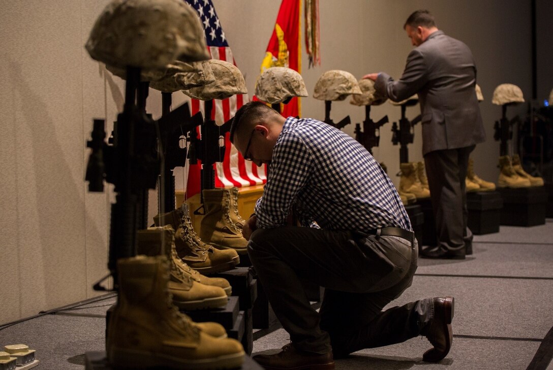 Marines and Sailors from 1st Battalion, 25th Marine Regiment, 4th Marine Division,  pay tribute to their fallen brothers at a display of Battlefield crosses during the unit’s 10-year reunion of its deployment to Fallujah, Iraq, here, Oct. 8, 2016. The unit lost 10 Marines and one Sailor during the seven-month deployment in 2006. (U.S. Marine Corps photo by Cpl. Melissa Martens/ Released) 