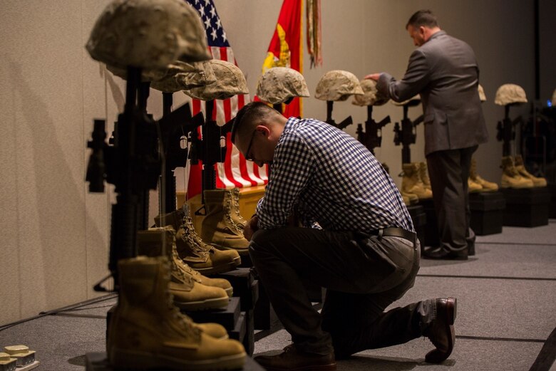 Marines and Sailors from 1st Battalion, 25th Marine Regiment, 4th Marine Division,  pay tribute to their fallen brothers at a display of Battlefield crosses during the unit’s 10-year reunion of its deployment to Fallujah, Iraq, here, Oct. 8, 2016. The unit lost 10 Marines and one Sailor during the seven-month deployment in 2006. (U.S. Marine Corps photo by Cpl. Melissa Martens/ Released) 