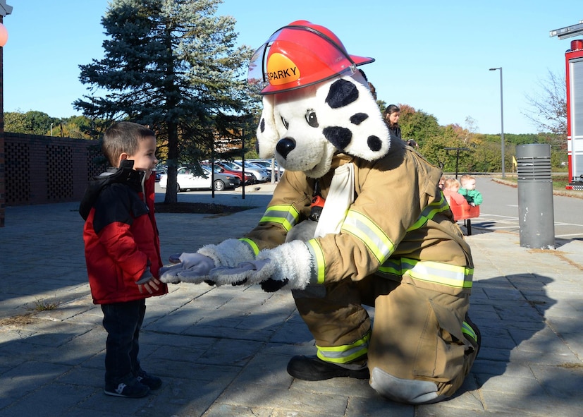 Sparky greets Thomas Berger and other children outside the Child Development Center as part of a National Fire Prevention Week event Oct. 12. The theme for this year's weeklong event is: "Don’t Wait – Check the Date! Replace Smoke Alarms Every 10 Years." (U.S. Air Force photo by Linda LaBonte Britt)