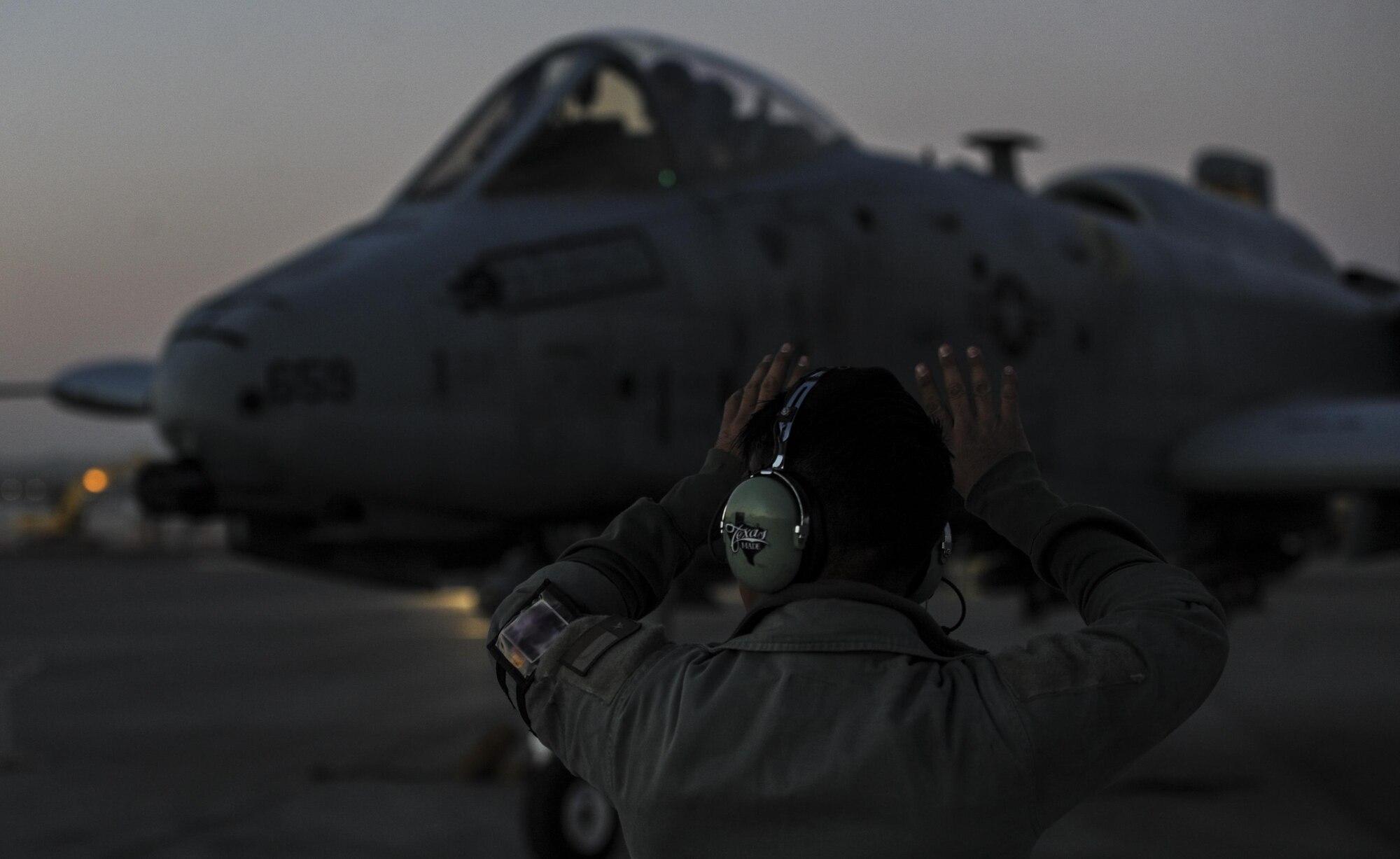 Senior Airman Scott Martinez, 355th Aircraft Maintenance Squadron crew chief, Davis-Monthan Air Force Base, Ariz., signals to an A-10 Thunderbolt II as the pilot taxis down the runway at Nellis Air Force Base, Nev., Oct. 4, 2016. The 357th Fighter Squadron is participating in a realistic air-land integration combat training exercise involving air forces of the U. S. and its allies. (U.S. Air Force photo by Airman 1st Class Kevin Tanenbaum/Released)