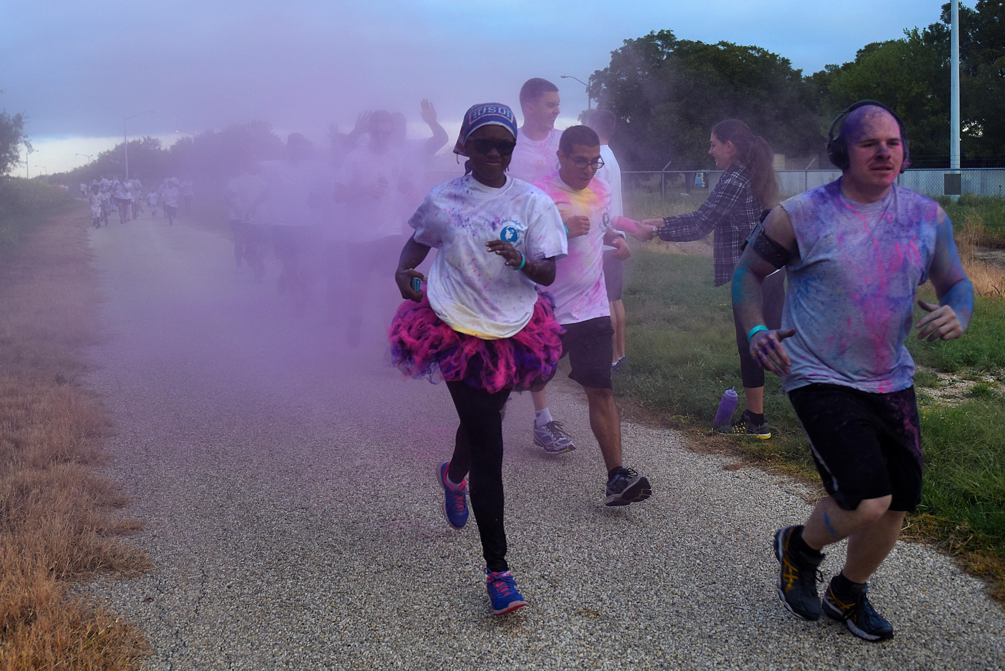 Participants during the annual Sexual Assault Prevention and Response Color Run jog along the Kiowa Trail on Goodfellow Air Force Base, Texas, Oct. 8, 2016. The SAPR office hosted the event to help bring awareness to sexual assault. (U.S. Air Force photo by Airman 1st Class Caelynn Ferguson/Released)