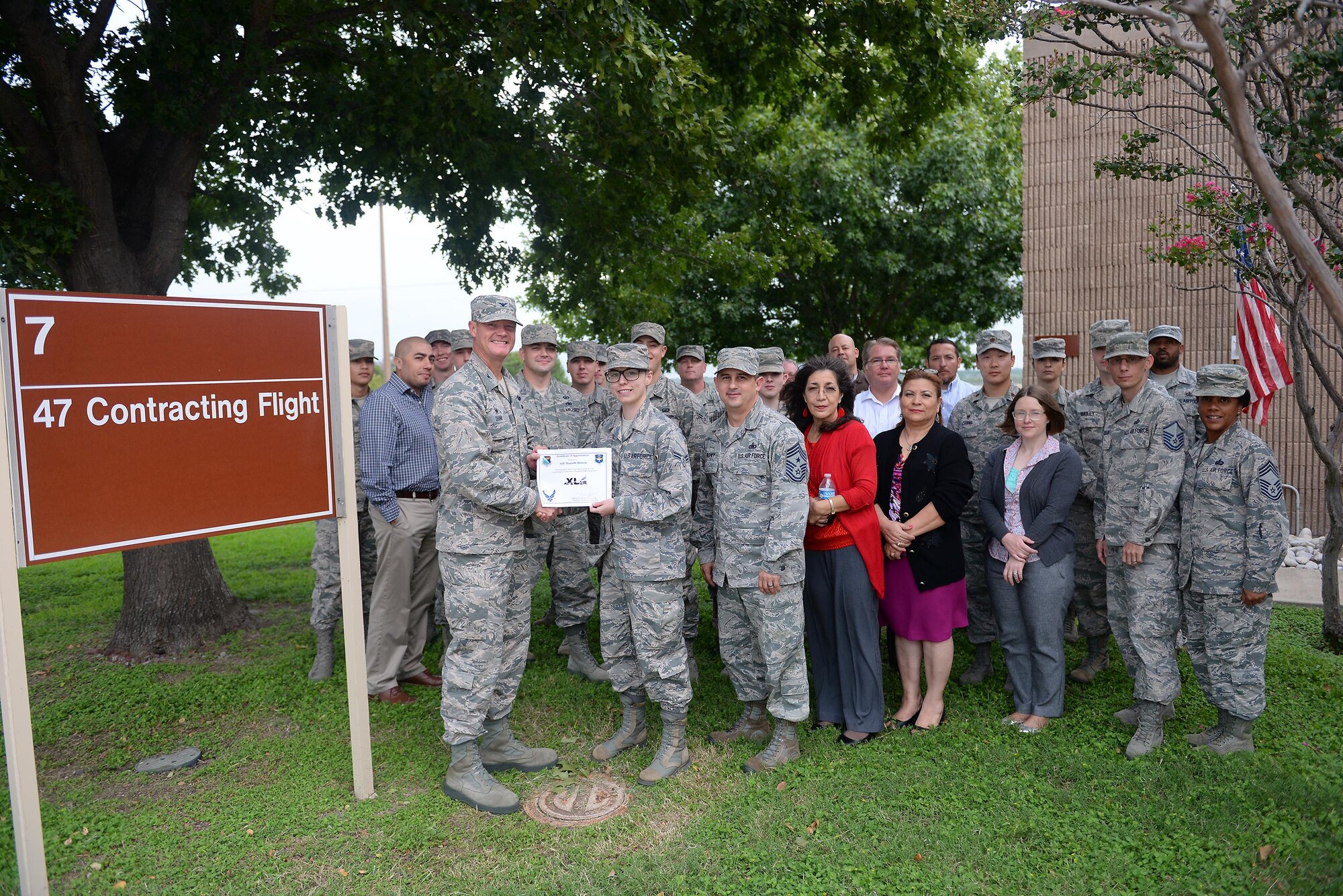 Airman 1st Class Danielle Britton, 47th Contracting Flight contracting specialist (front center), accepts the “XLer of the Week” award from Col. Thomas Shank (front left), 47th Flying Training Wing commander, on Laughlin Air Force Base, Texas, Oct. 4, 2016. The XLer is a weekly award chosen by wing leadership and is presented to those who consistently make outstanding contributions to their unit and Laughlin. (U.S. Air Force photo/Airman 1st Class Benjamin N. Valmoja)