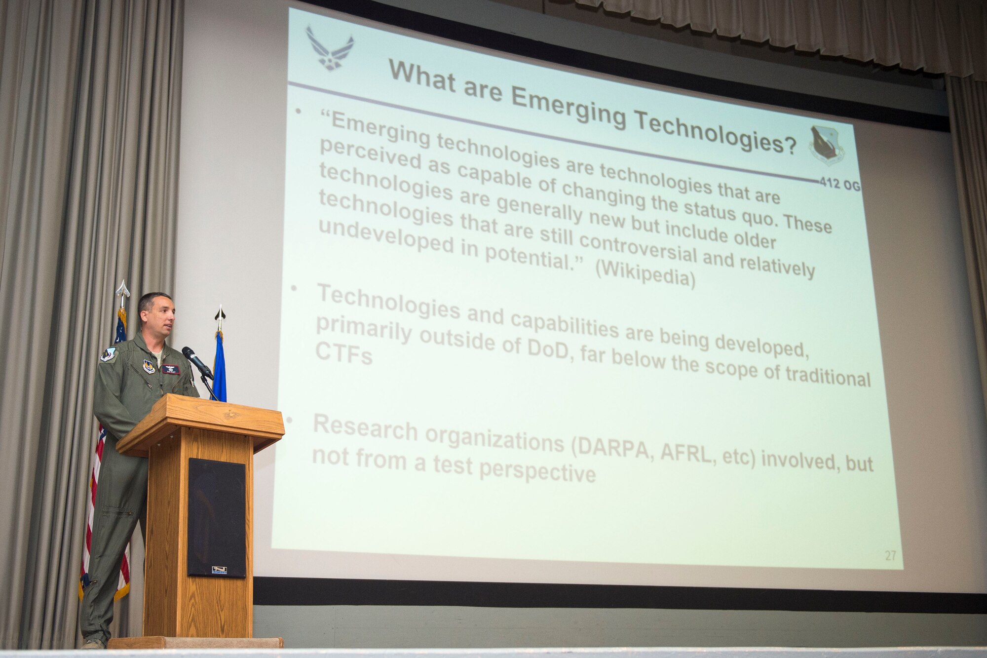 Maj. Dan Riley, Emerging Technologies Combined Test Force director, speaks about the new CTF at a 412th Operations Group commander's call in the base theater Oct. 3. (U.S. Air Force photo by Ethan Wagner)