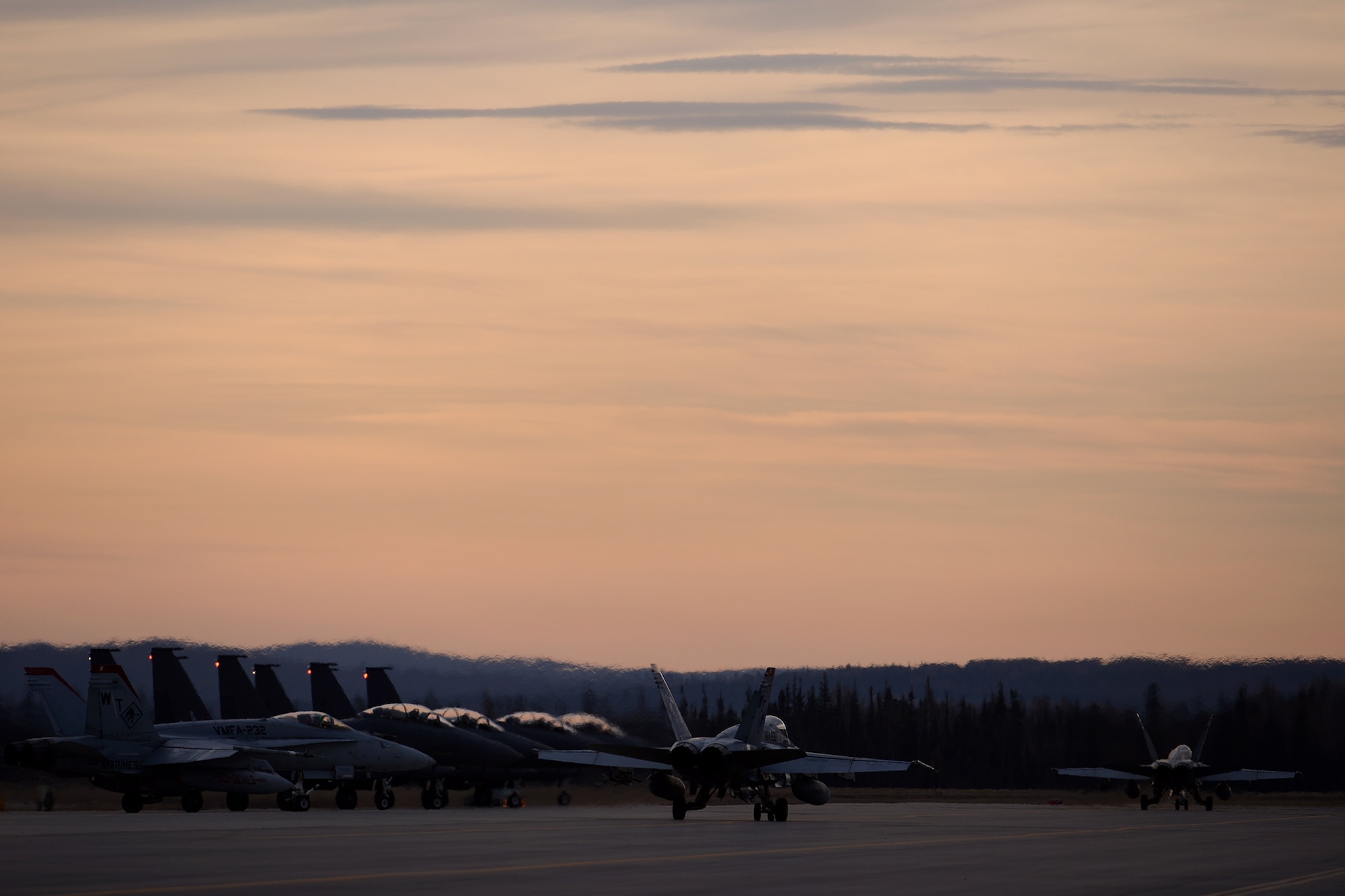 U.S. Marine Corps F/A-18C Hornet aircraft with Marine Fighter Attack Squadron 232 out of Marine Corps Air Station Miramar, Calif., taxi past Republic of Korea F-15K Slam Eagle aircraft as they proceed to the end of the Eielson Air Force Base, Alaska, runway Oct. 10, 2016, for the first RED FLAG-Alaska (RF-A) 17-1 mission. This exercise provides unique opportunities to integrate various forces into joint, coalition and multilateral training from simulated forward operating bases. (U.S. Air Force photo by Master Sgt. Karen J. Tomasik)