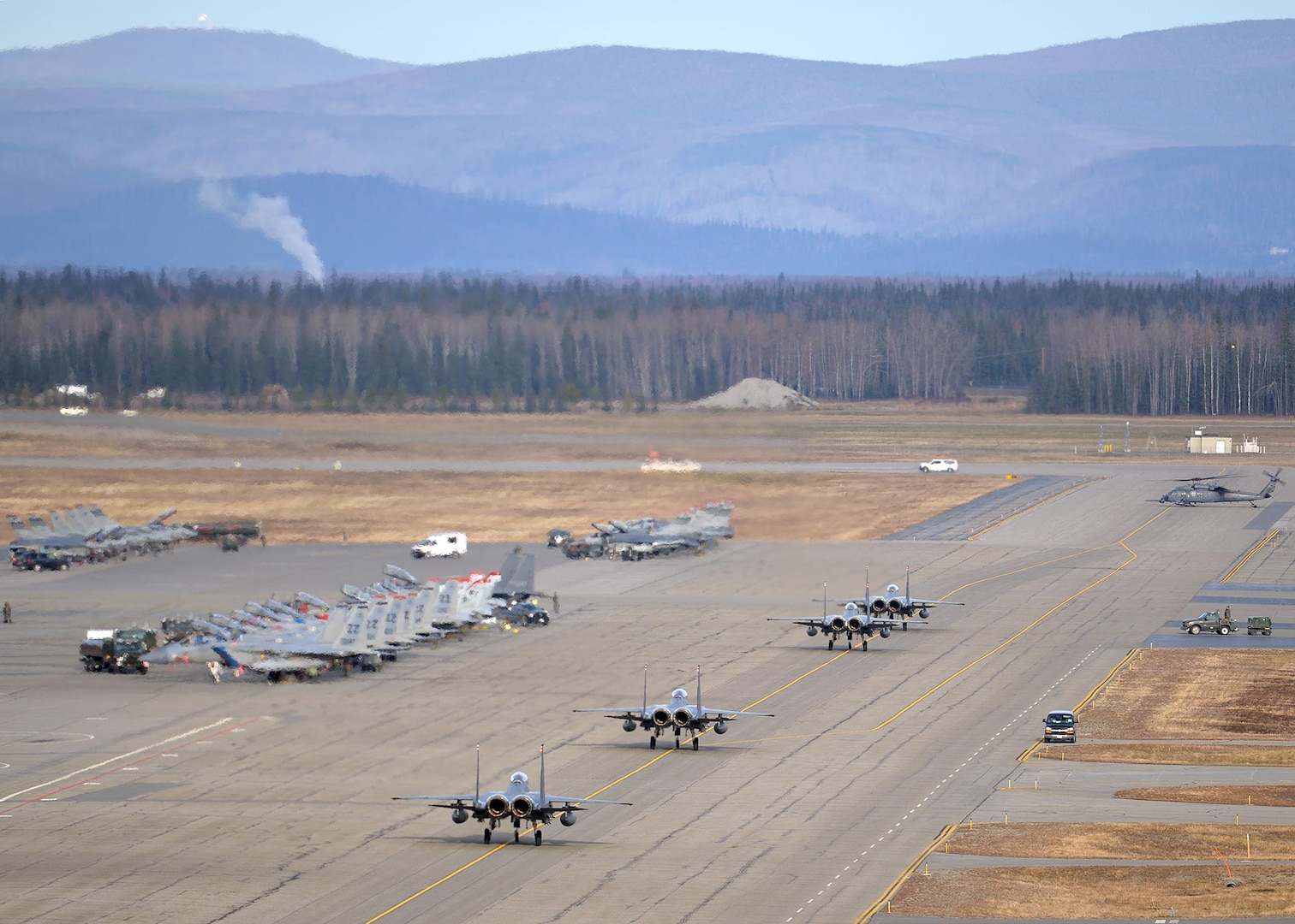Republic of Korea Air Force (ROKAF) F-15K Slam Eagle multi-role fighter aircraft taxi toward their ramp space on the Eielson Air Force Base, Alaska, flight line Oct. 10, 2016, as a U.S. Air Force HH-60 Pave Hawk helicopter assigned to the 210th Rescue Squadron prepares for its own mission after the first RED FLAG-Alaska (RF-A) 17-1 combat training sortie ended. RF-A is a series of Pacific Air Forces commander-directed field training exercises vital to maintaining peace and stability in the Indo-Asia-Pacific region, and providing U.S. units and partner nation forces the opportunity to sharpen their combat skills and strengthen interoperability inside more than 67,000 square miles of airspace in the Joint Pacific Alaska Range Complex. (U.S. Air Force photo by Master Sgt. Karen J. Tomasik)