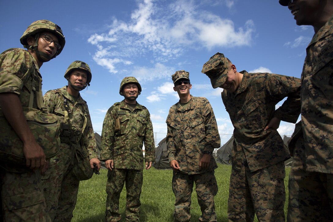 – Japan Ground Self-Defense Force service members and U.S. Marines introduce themselves during the annual Guard and Protect, an observe and exchange event Oct. 7 aboard Marine Corps Air Station Futenma, Okinawa, Japan. The event was a three-day training evolution that allowed U.S. service members and Japan Ground Self-Defense Force service members to observe each other’s tactical procedures and operations while building the bilateral relationship between U.S. service members and its host nation. The exchange included reinforcing troop movement, vehicle inspections, and the escalation of force. 