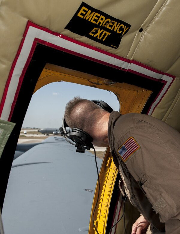 U.S. Air Force Staff Sgt. Jeffrey, 22nd Expeditionary Air Refueling Squadron (EARS) boom operator, looks out an emergency exit door to relay aircraft flap movements to the aircraft’s pilot during a preflight inspection Sept. 19, 2016, at Incirlik Air Base, Turkey. Jeffrey positon allows him to provide a blind spot buffer for pilots and relay information over the aircraft radio. (U.S. Air Force photo by Staff Sgt. Jack Sanders)