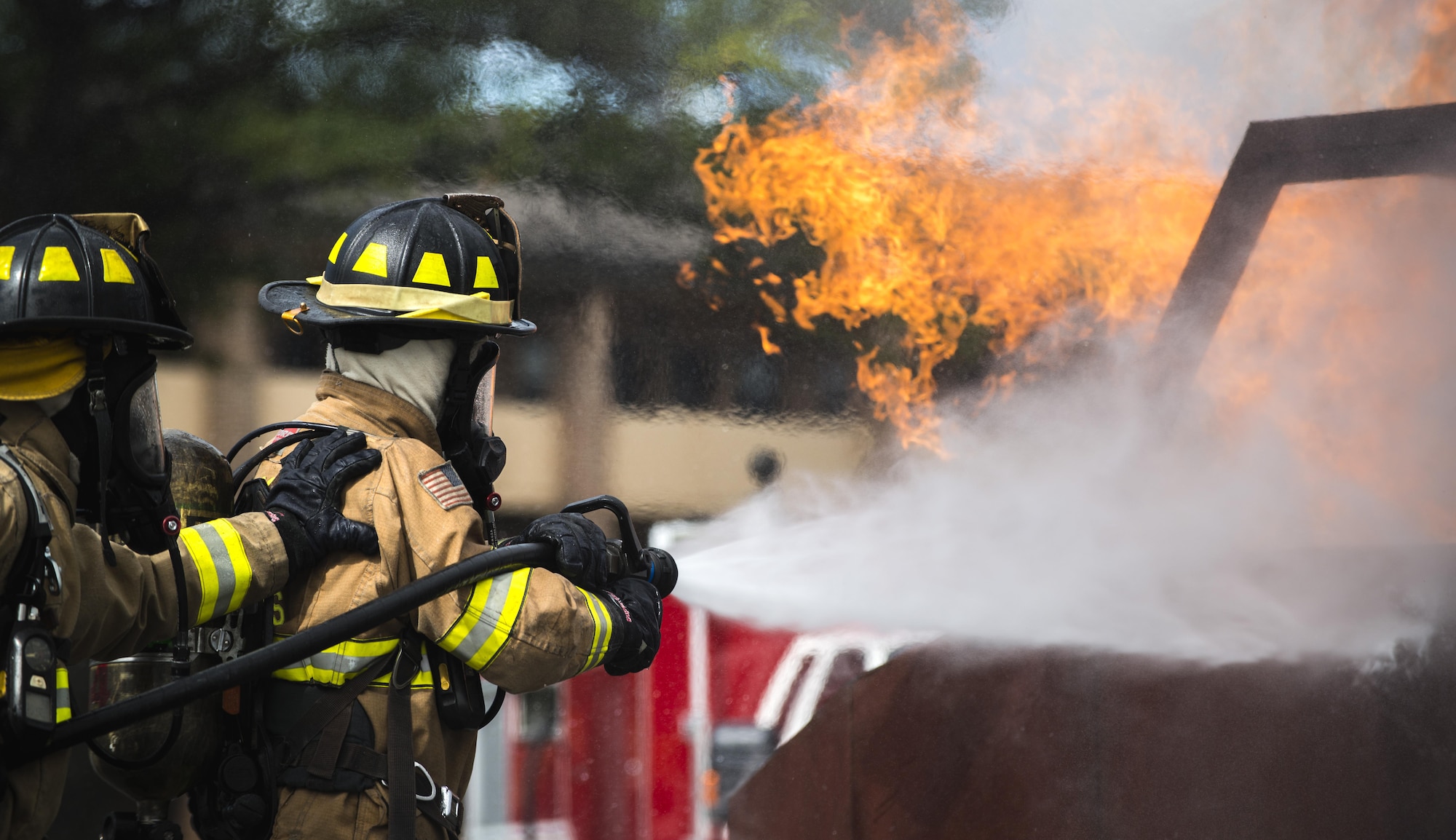 Airman 1st Class Austyn Helgeson and Senior Airman Scott Burdick, 11th Wing Civil Engineer firefighters, put out a fire during a live fire exercise at Joint Base Andrews, Md., Oct. 7, 2015. The exercise was part of the fire prevention week on JBA. (U.S. Air Force photo by Airman 1st Class Philip Bryant/Released)