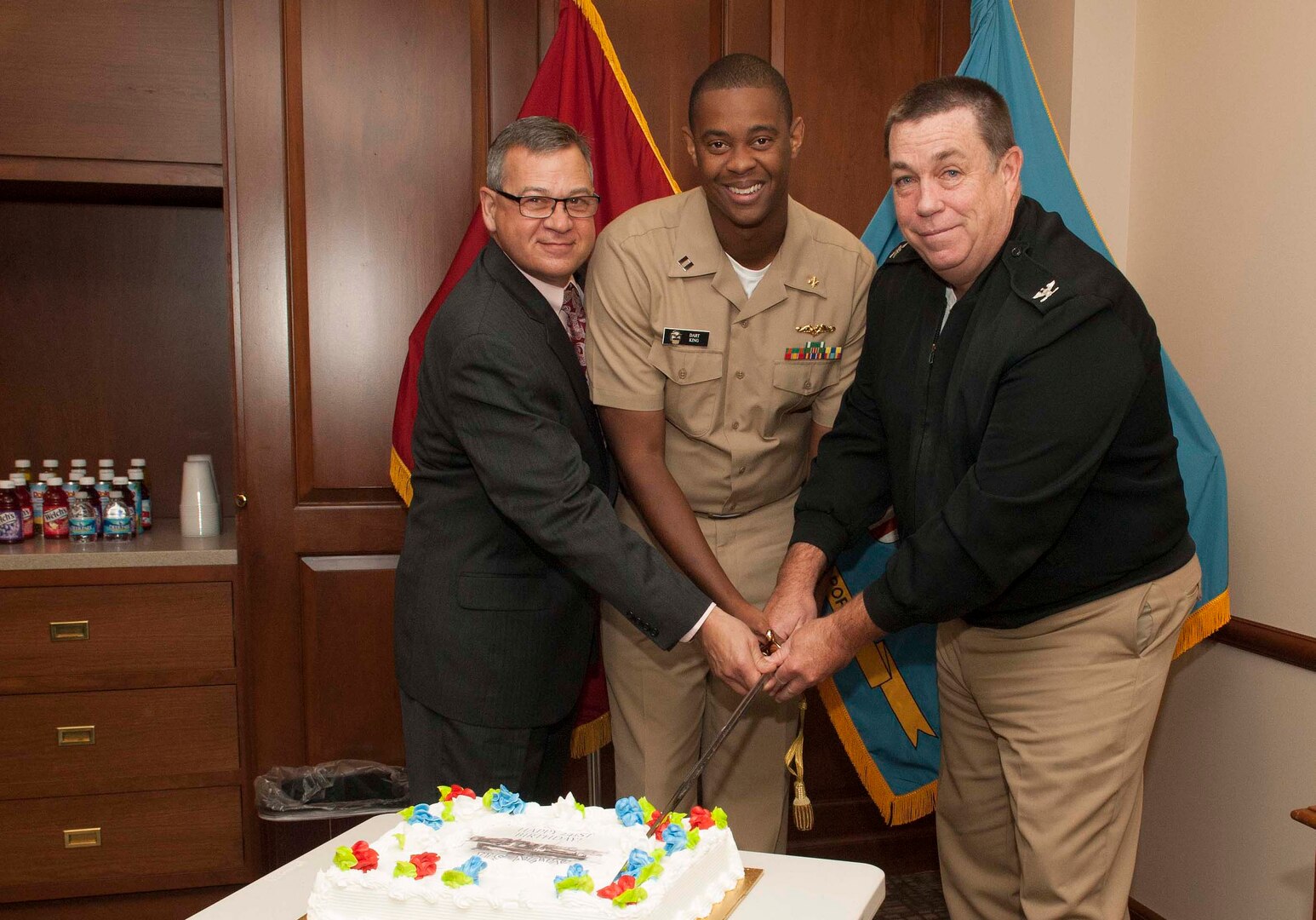 DLA Troop Support Deputy Commander Richard Ellis, Lt. Dartanyon King, Subsistence contract specialist, and Navy Capt. Daniel Hodgson, Construction and Equipment director, cut a cake in honor of the Navy’s 241st birthday during a ceremony Oct. 11. 