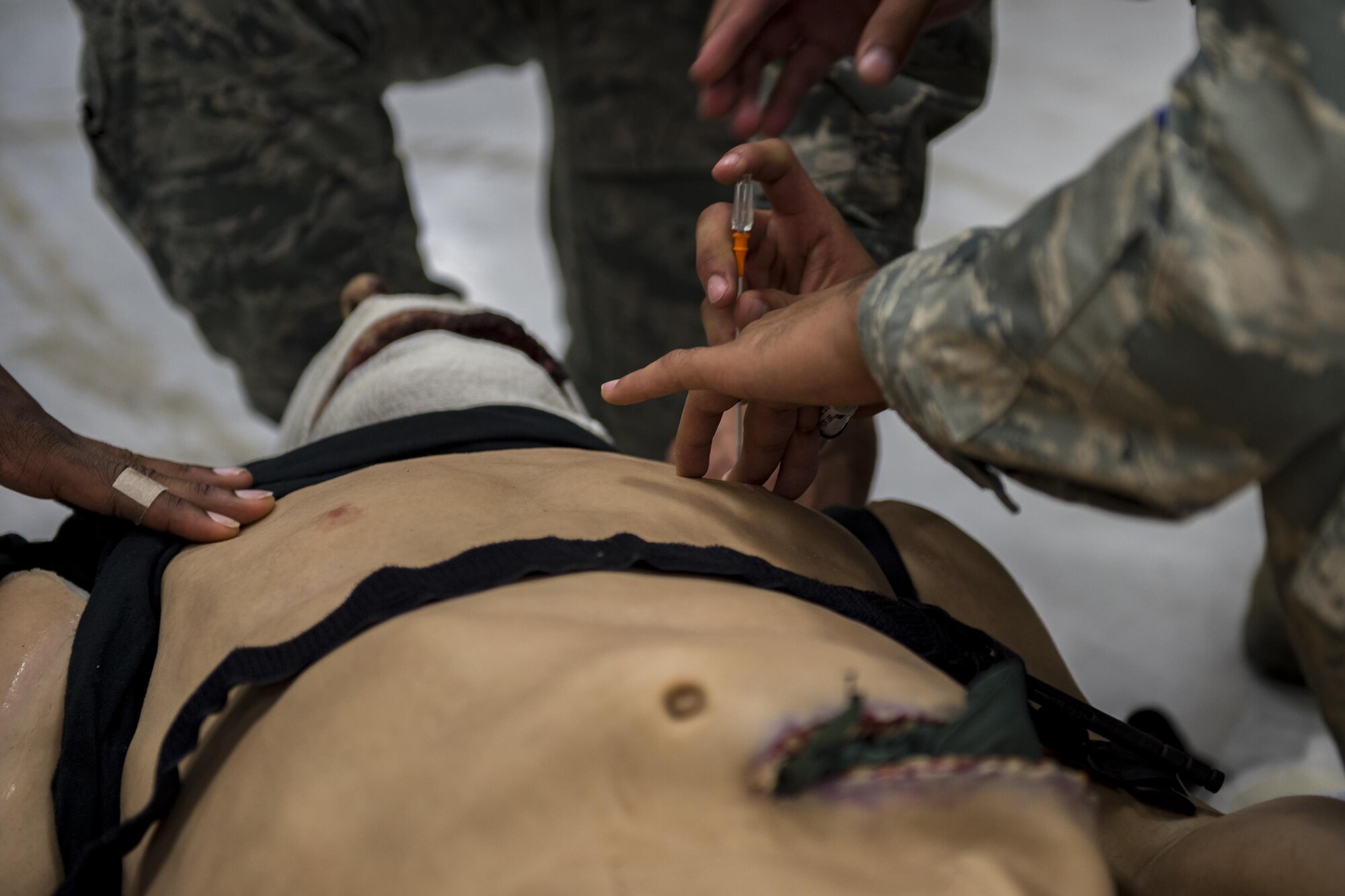 Airman 1st Class Gerardo Balsa, 105th Base Defense Squadron security forces member, demonstrates how to perform a needle decompression on the chest during tactical combat casualty care training, Sept. 29, 2016, at Moody Air Force Base, Ga. Tactical combat casualty care tests and reinforces participants’ lifesaving medical skills while they are in high-stress, combat scenarios. (U.S. Air Force photo by Tech. Sgt. Zachary Wolf)