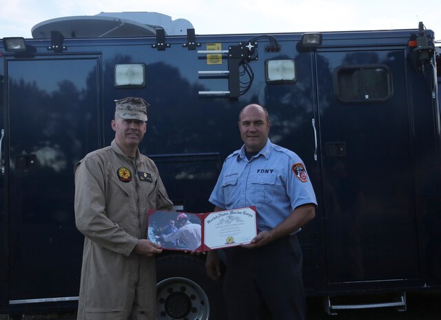 Lt. Col. Shaun T. Fitzpatrick, executive officer for Chemical Biological Incident Response Force, CBIRF, and Initial Response Force, IRF B, mission commander, presents a certificate of appreciation to Fire Capt. Michael Smithwick for his work in support of CBIRF during the training exercise with the Fire Department of New York, FDNY, on Randall’s Island, N.Y., Sept. 15, 2016. CBIRF’s Marines and sailors participated in a training event that included three days of lane training with FDNY instructors teaching classes in vehicle extrication, breaching, rope rescue and medical as part of urban rescue operations, and a final training operation in which CBIRF responded to a notional steam plant explosion. (Official U.S. Marine Corps photo by Lance Cpl. Maverick S. Mejia/RELEASED)
