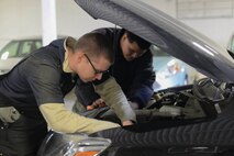 Airman 1st Class Cameron Longnecker, 5th Logistics Readiness Squadron vehicle maintenance technician, inspects an engine at Minot Air Force Base, N.D., Oct. 7, 2016. Airmen checked fluids, tires and headlights to ensure customer vehicles were in proper working condition for the upcoming winter. (U.S. Air Force photo/Airman 1st Class Jessica Weissman)