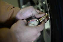 An Airman from the 5th Logistics Readiness Squadron vehicle maintenance section checks the pressure in a tire at Minot Air Force Base, N.D., Oct. 7, 2016. Airmen focused the inspection on helping spouses of deployed Airmen winterize their vehicles. (U.S. Air Force photo/Airman 1st Class Jessica Weissman)