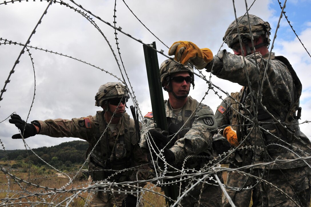 U.S. Army Reserve combat engineer Soldiers attached to the 402nd Engineer Company-Sappers lay a concertina wire obstacle during exercise Allied Spirit V at the Joint Multinational Readiness Center, Hohenfels, Germany, Oct. 2. Allied Spirit V is a U.S. Army Europe-directed, 7th Army Training Command-conducted multinational exercise focused on multinational, unified land operations, and promoting both the interoperability and integration of multinational partners.