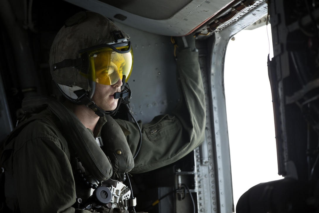 A U.S. Marine with Marine Medium Tiltrotor Squadron 365, 24th Marine Expeditionary Unit (24th MEU), looks out from a CH-53E super stallion helicopter during a disaster relief mission at Port-au-Prince, Haiti, Oct. 10, 2016. The 24th MEU is part of a larger U.S. response to the government of Haiti request for humanitarian assistance. The U.S. effort is coordinated by the Department of State and the U.S. Agency for International Development. (U.S. Marine Corps photo by Lance Cpl. Melanye E. Martinez)