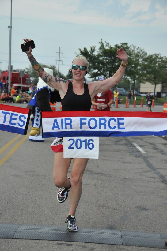 Staff Sgt. Anne Pennington, 701st Munitions Support Squadron NCO in charge of support at Kleine Brogel Air Base, Belgium, crosses the finish line to become the winner of the 20th U.S. Air Force Marathon women’s 5K division at Wright-Patterson Air Force Base, Ohio, with a time of 21:06. Pennington broke the Air Force record for her respective category during this run. (U.S. Air Force courtesy photo)