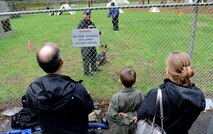 Ben Lambertson (middle) and his parents Paul (left) and Michelle (right), watch a Military Working Dog demo during his Pilot for a Day visit Oct. 7, 2016 at Joint Base Lewis-McChord, Wash. While at the MWD demo, Ben and his family had a chance to interact with the canines, and observe working dogs doing some obedience training and bite work. (U.S. Air Force photo/Senior Airman Divine Cox)